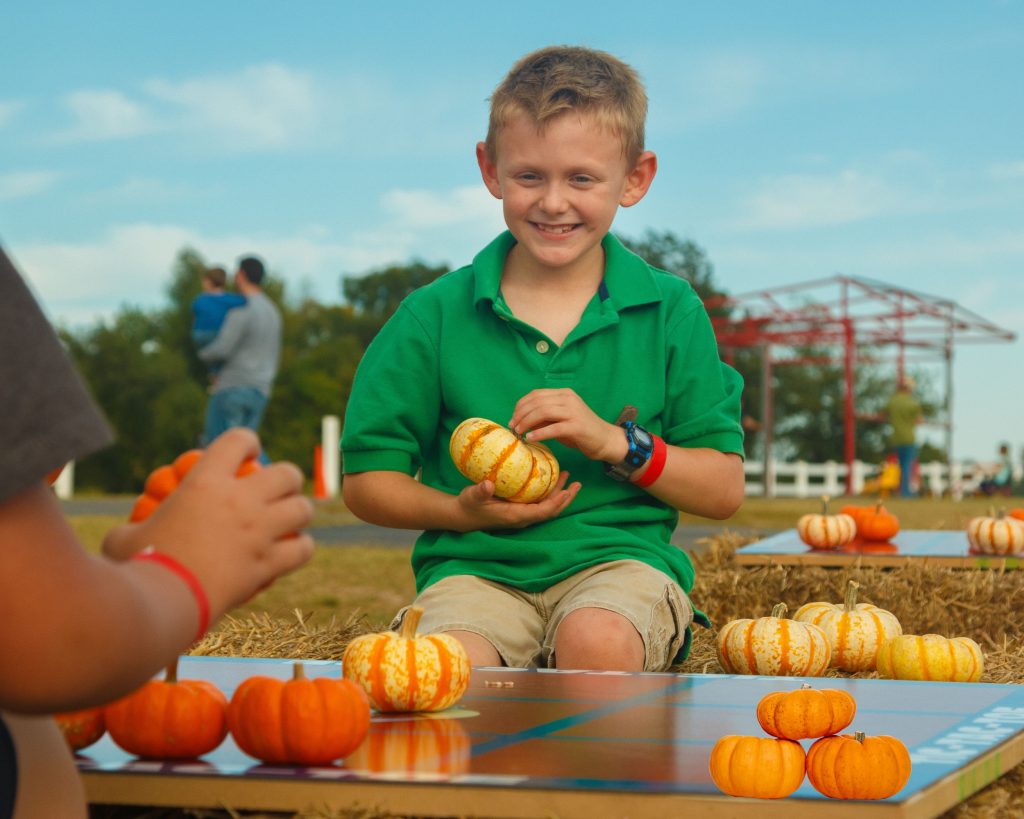 Create a DIY Pumpkin Tic Tac Toe game with small pumpkin in two different colors and paninter's tape to make the tic tac toe board. An easy Fall game for kids.